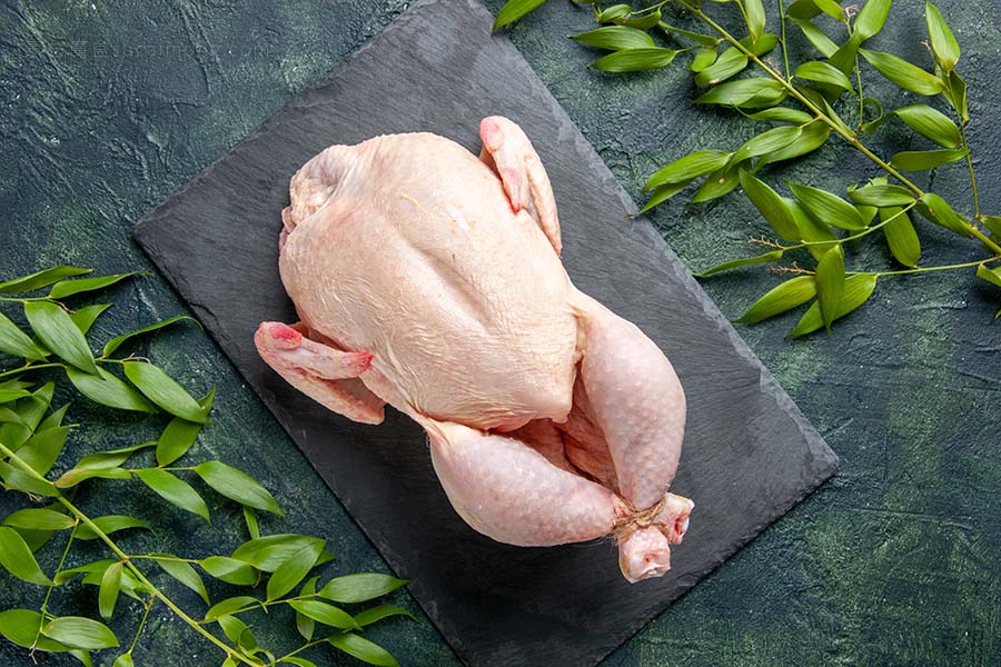 顶视图新鲜生鸡肉与绿色叶子在深色背景鸡肉粉动物肉照片食品颜色厨房