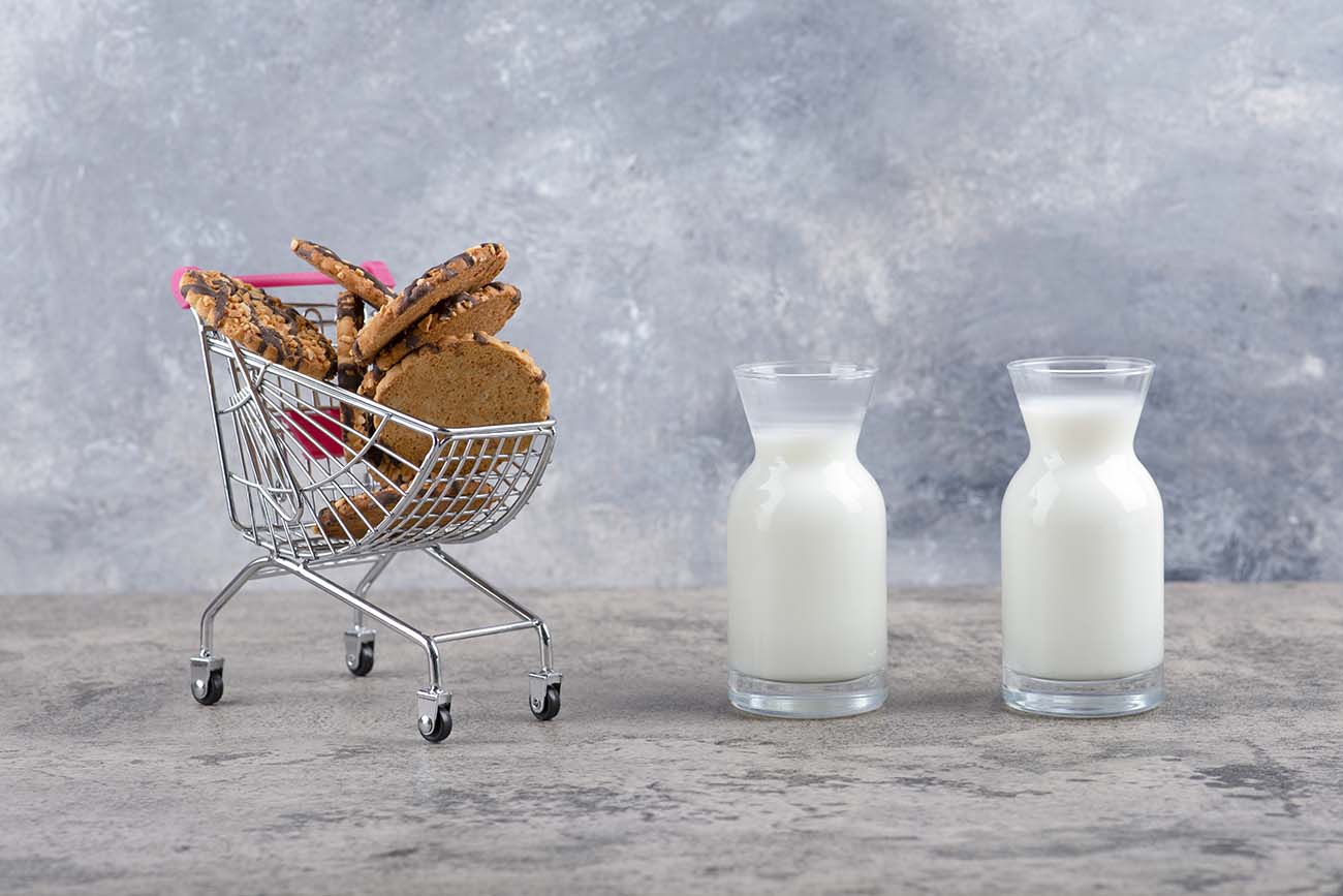 玻璃罐的新鲜牛奶和美味的饼干放在大理石桌子上