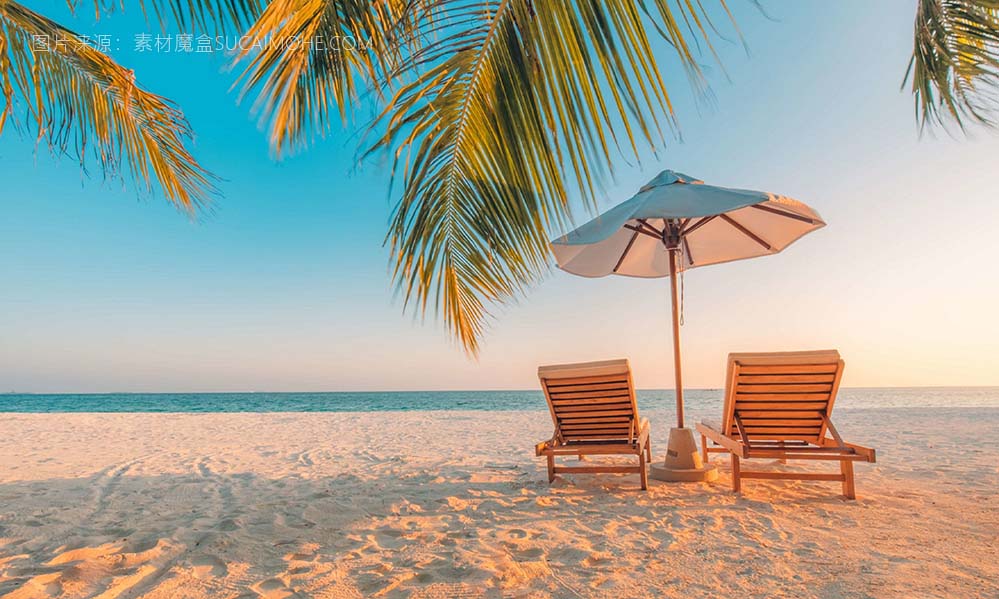 海边沙滩遮阳伞下的两个躺椅