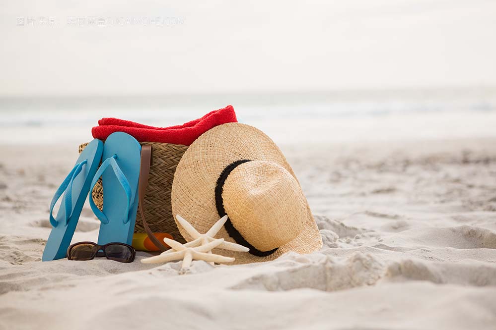 袋子和沙滩配件放在沙滩上照片