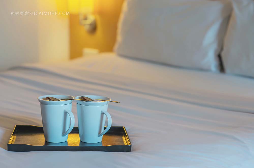 在酒店房间的白色床上的双胞胎欢迎咖啡杯子的关闭-旅馆好招待假期旅行