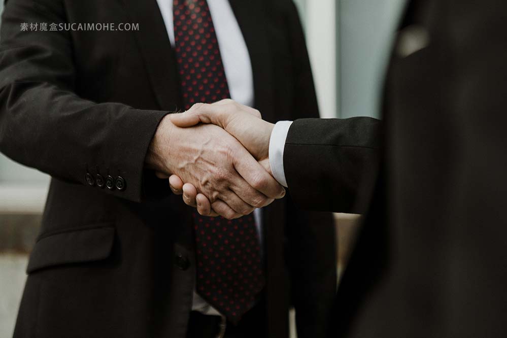商人做生意谈判成功后握手