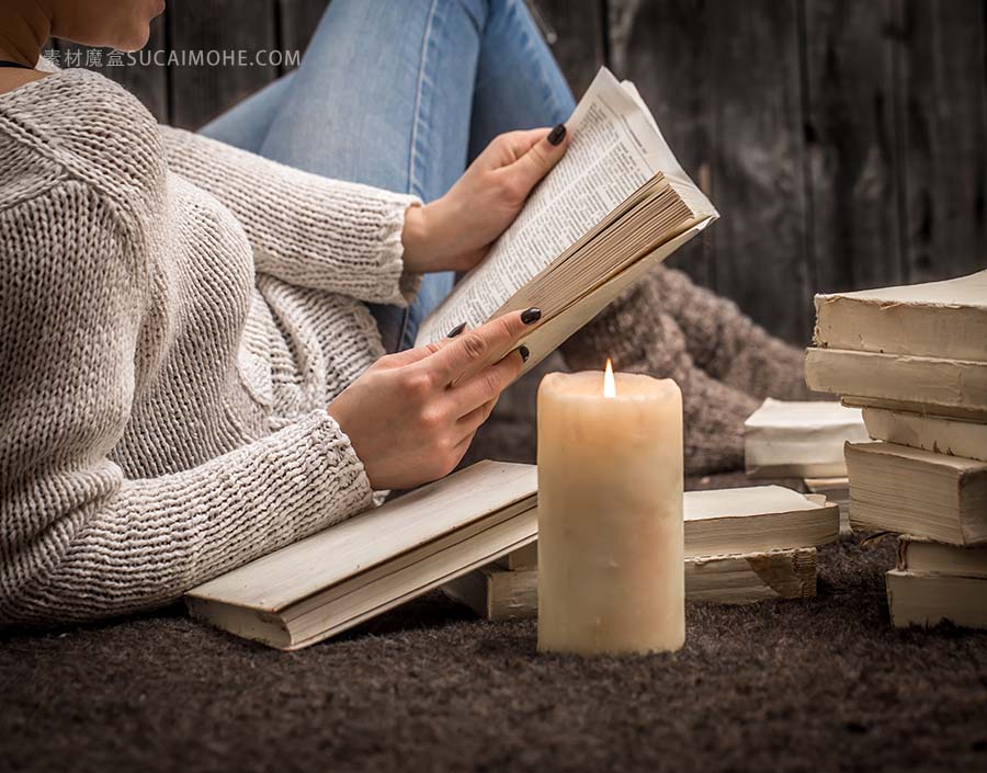 女孩坐在地上被许多白皮书和一支大蜡烛包围的照片girl-sitting-floor-surrounded-by-many-white-books-la