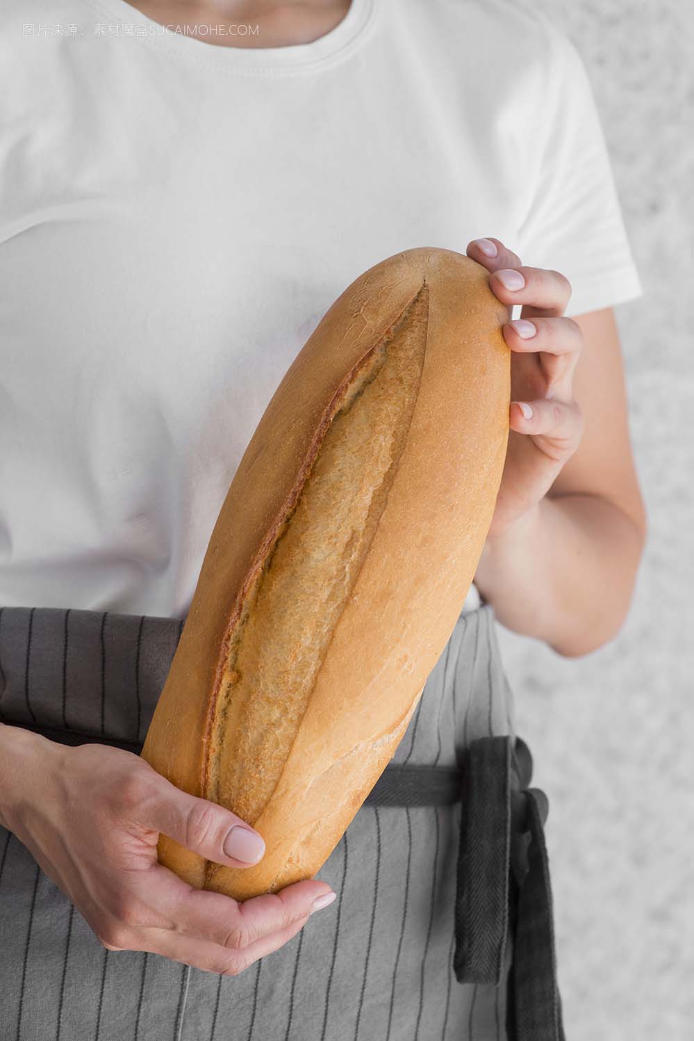 妇女拿着新鲜的法式面包close-up-woman-holding-fresh-baguette
