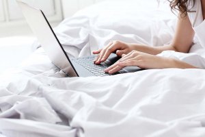 lovely-woman-with-laptop-bed